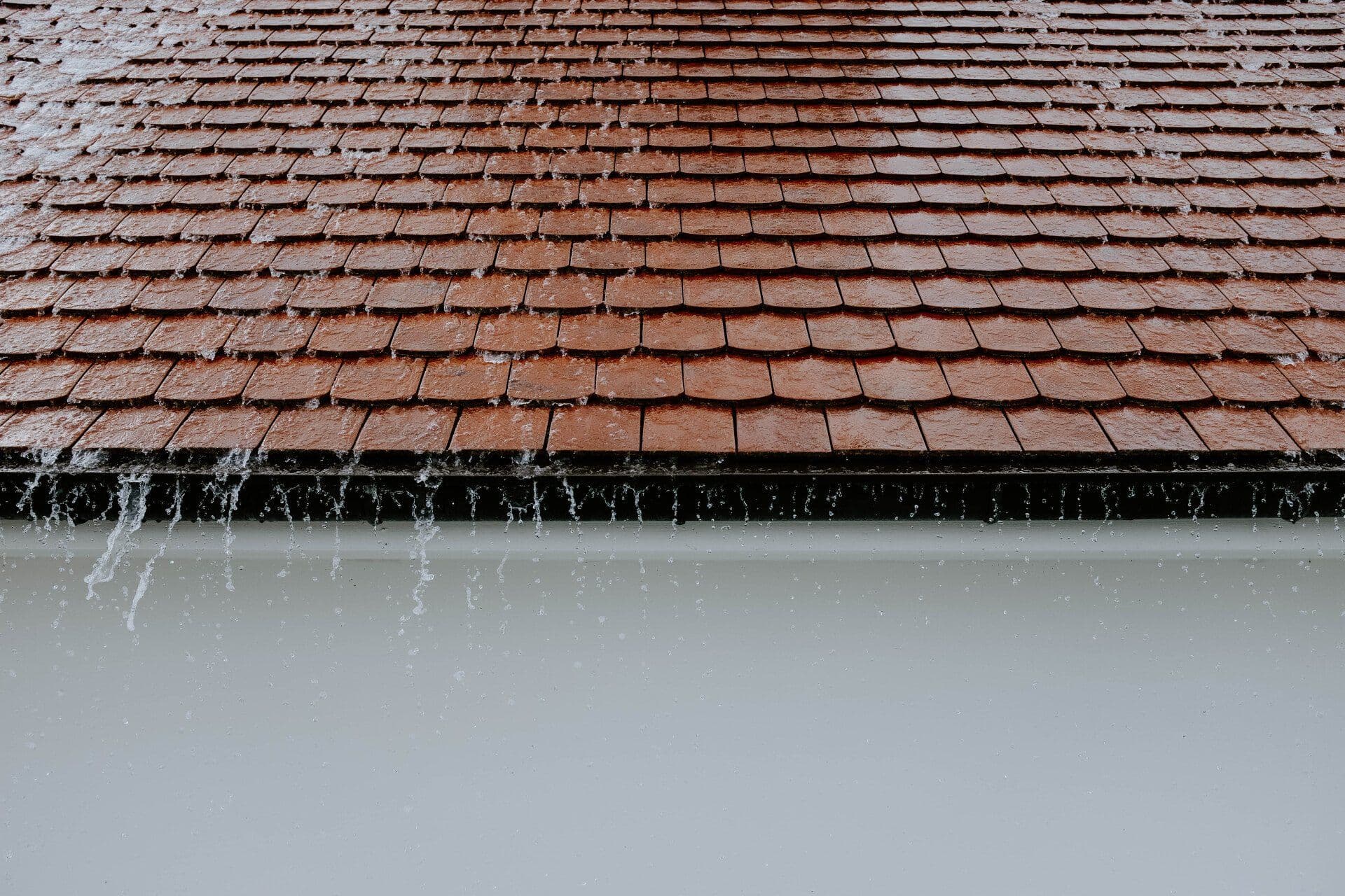 Rainwater draining off a properly installed roof — installation that holds up to Minnesota weather