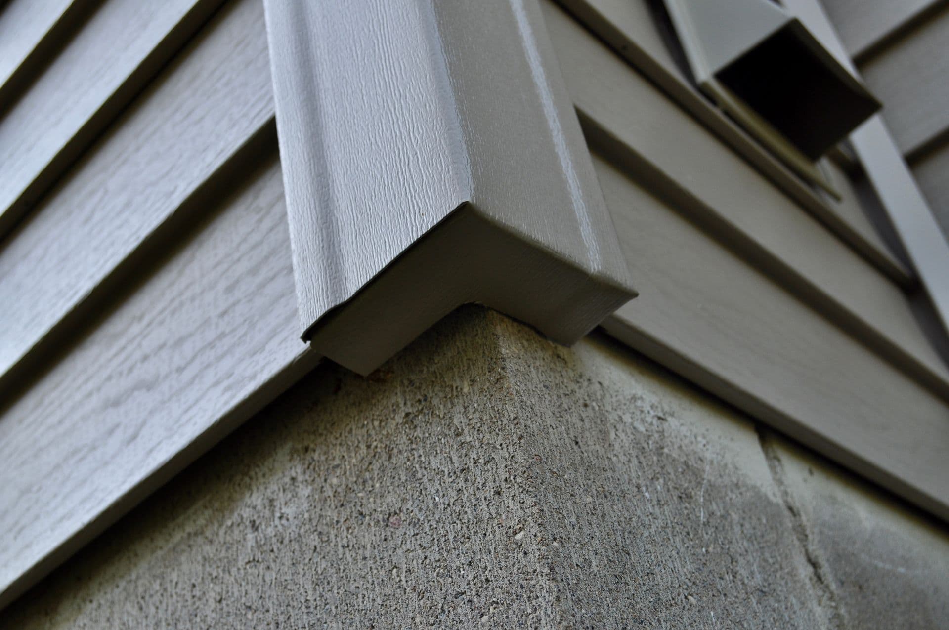 Close-up of a siding corner detail — the kind of transition Modex documents before quoting a repair versus replace