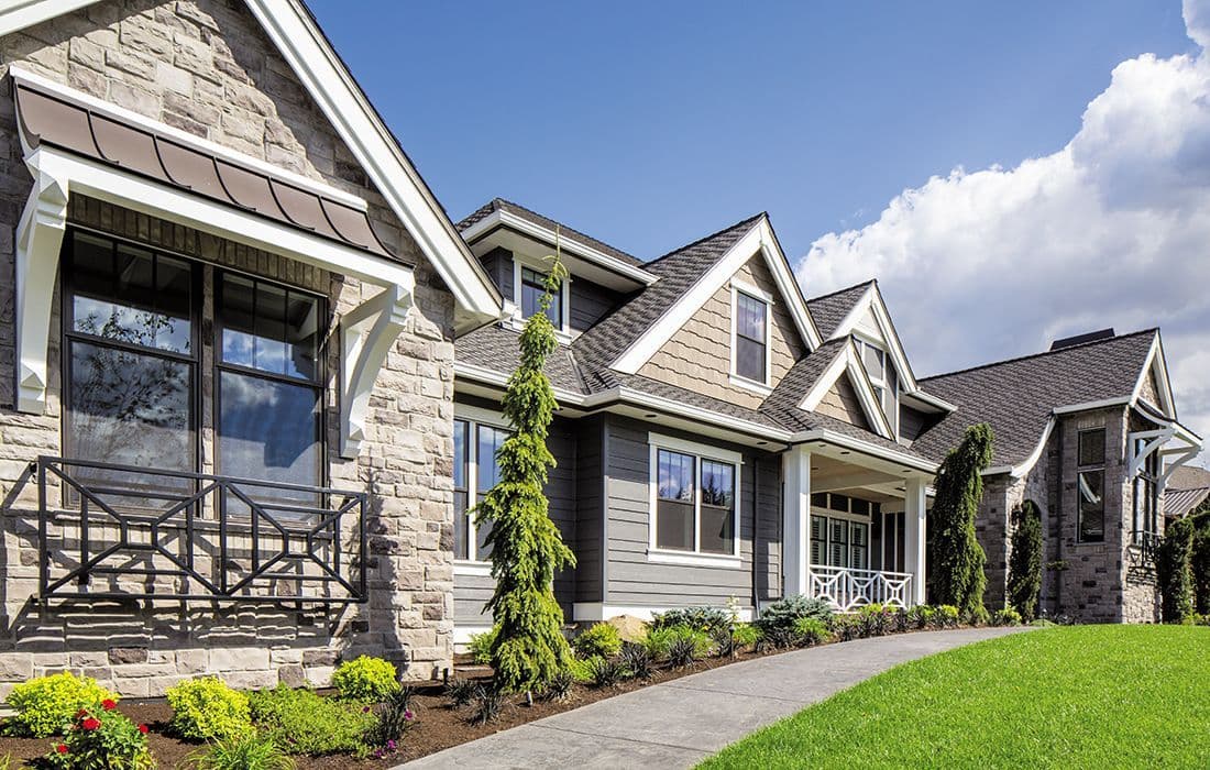 Modern home featuring stone and siding combination with landscaped front yard