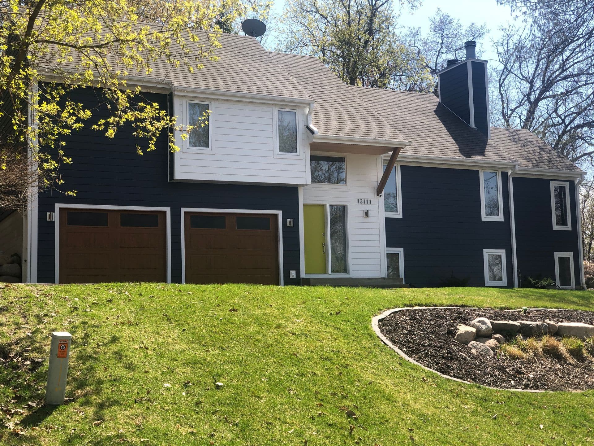 A completed Modex LP SmartSide siding install on a modern blue and white residential home
