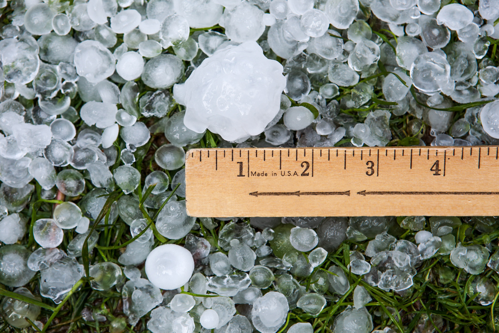 2-inch hailstones measured against a ruler on grass — the UL 2218 Class 4 impact benchmark